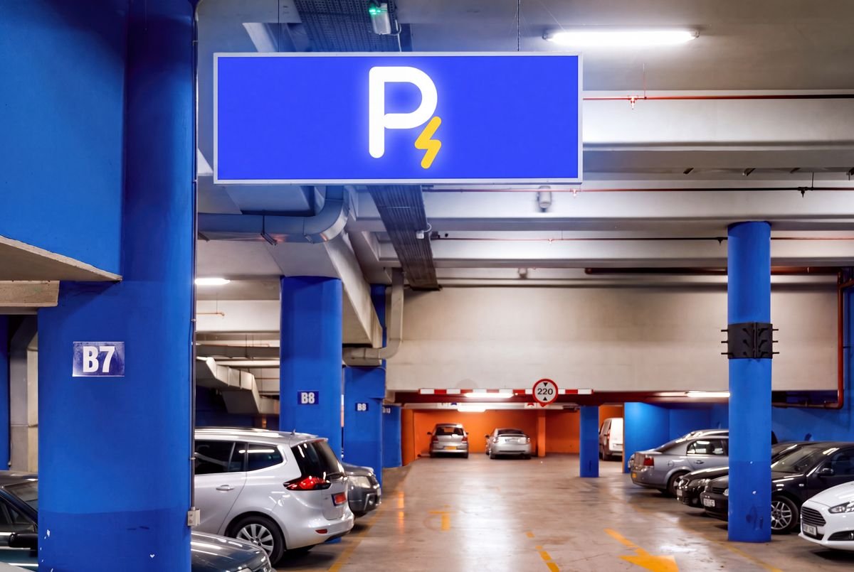 Parqueadero cubierto con un aviso azul que muestra el símbolo de Recargados: una P blanca con un rayo dorado.